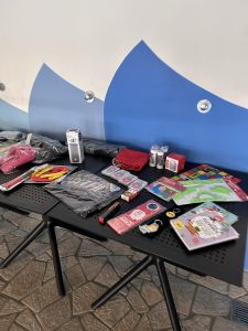 Tisch mit Preisen, darunter Schwimmzubehör und verpackte Gegenstände.
