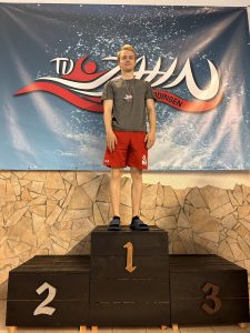 Teilnehmer mit roter Hose und Medaille auf Platz eins.