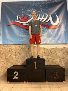Teilnehmer mit roter Hose und Medaille auf Platz eins.