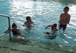 Kinder im Wasser am Einstiegsbereich des Schwimmbeckens.