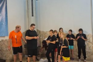 Gruppe mit Medaillen steht vor dem Siegerpodest.